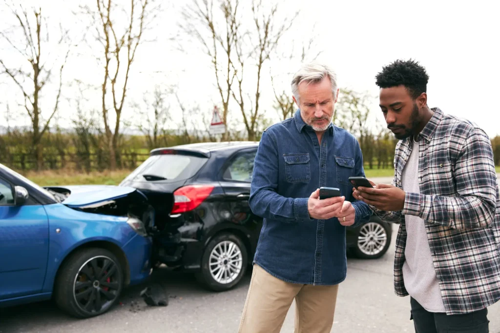 two men exchanging contact information after a car accident