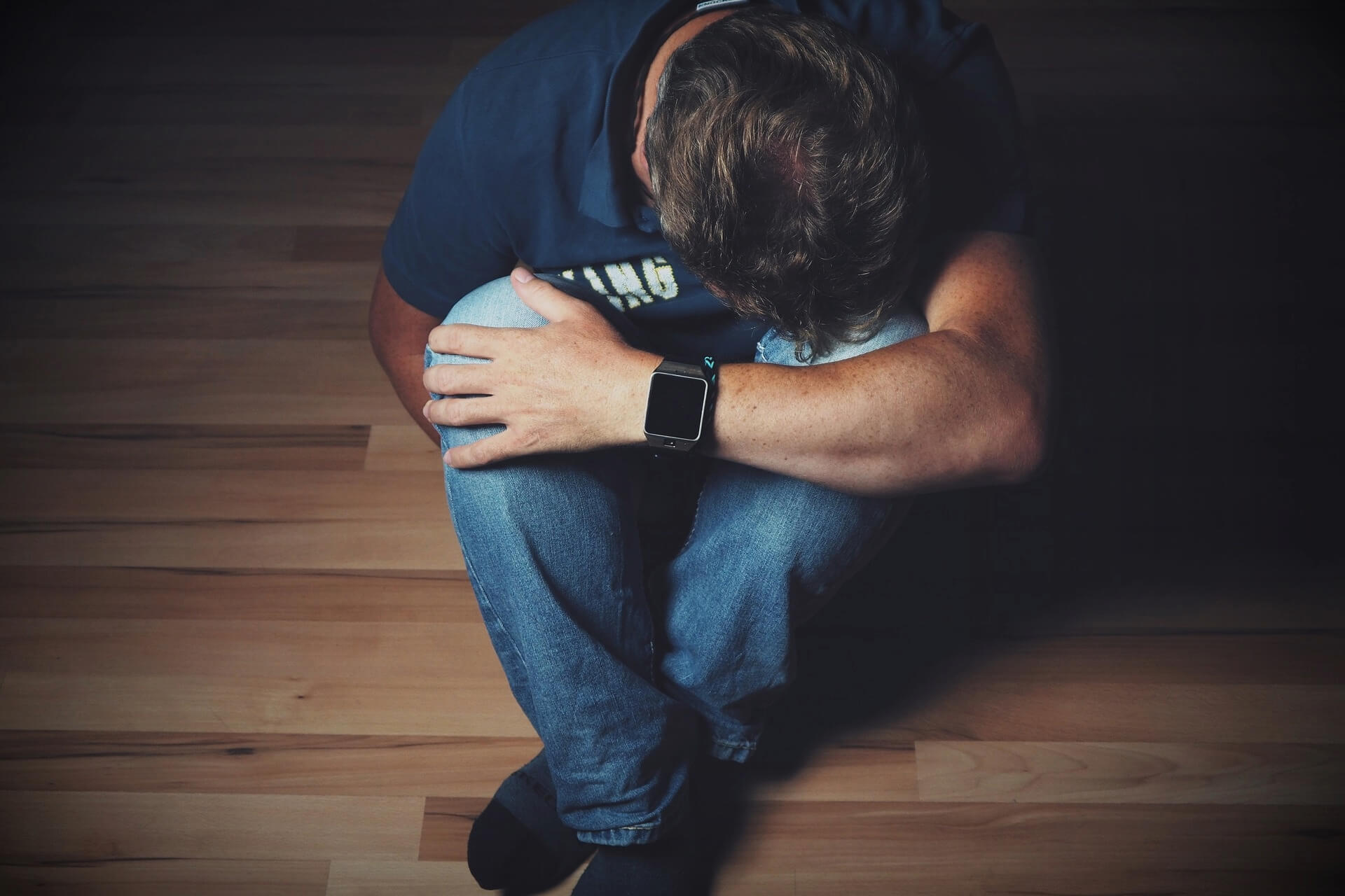 man sat on the floor after losing a loved one