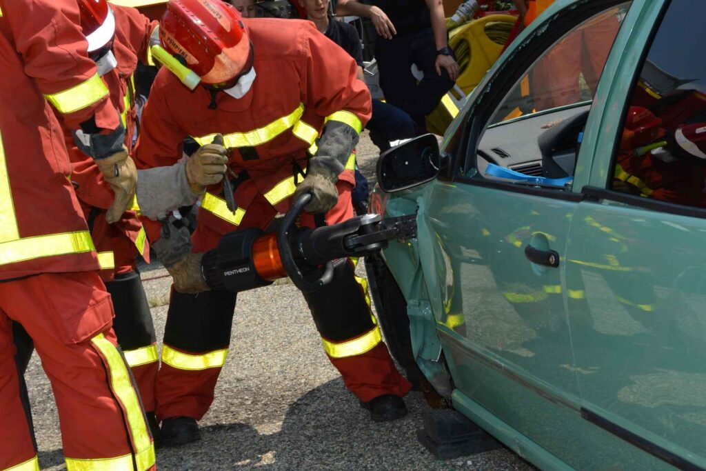 firefighter help people get out from car after accident