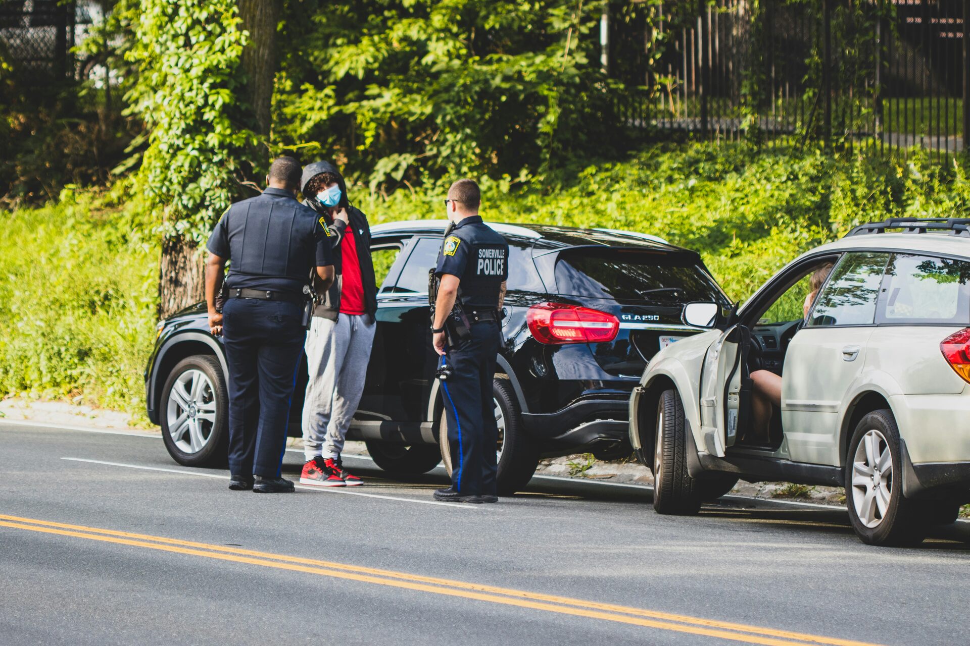 Somerville police officers conducting traffic stop with masked individual