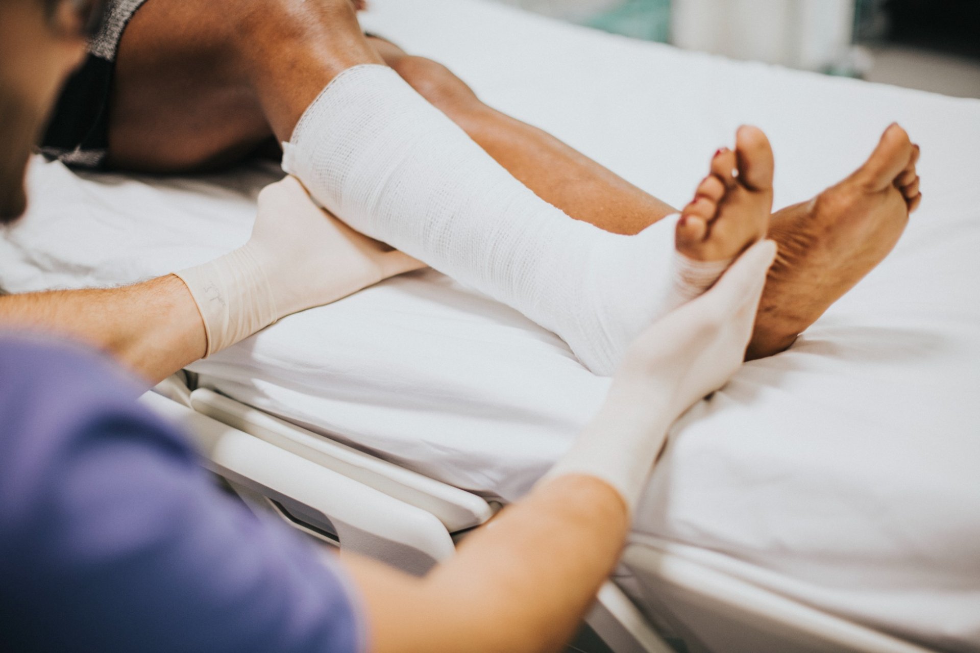 Doctor examining leg cast of injured patient in medical setting