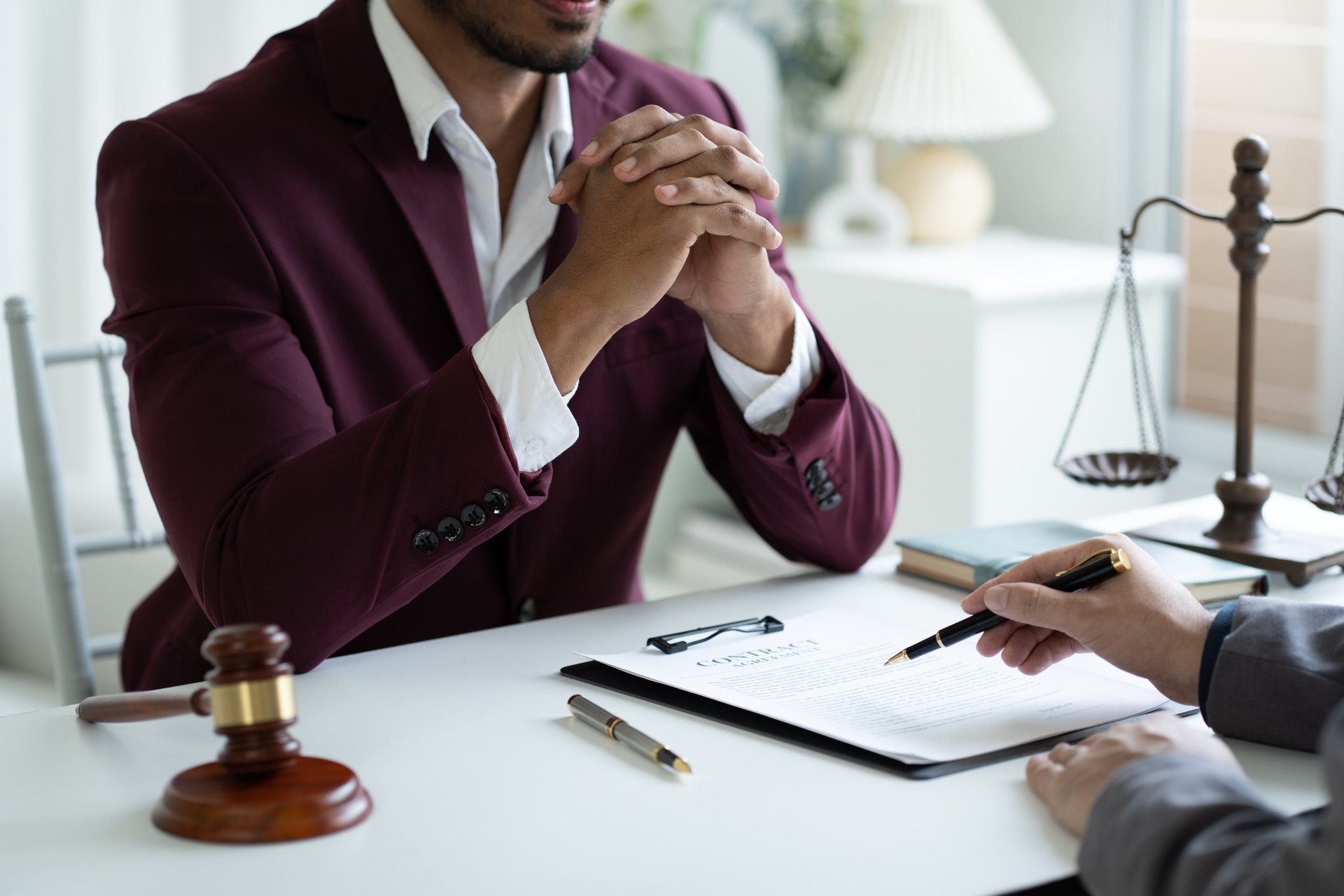 Young lawyer in a suit advising a client at a modern office