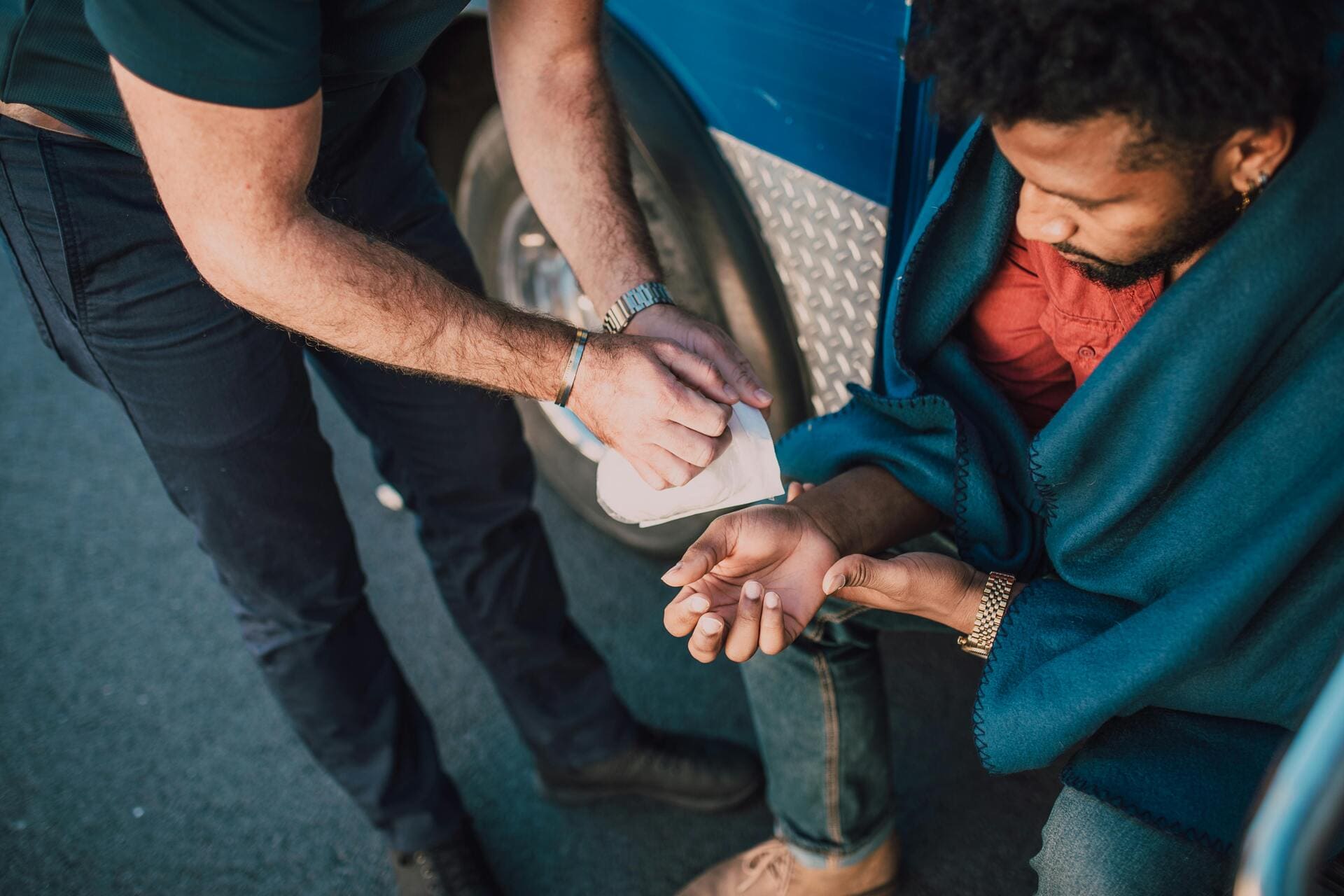 First responder treating a man’s injured hand after an accident