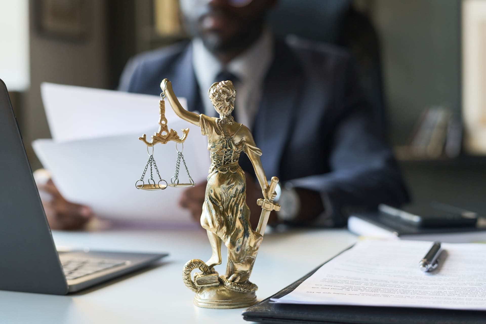 Golden Lady Justice statue on lawyer’s desk