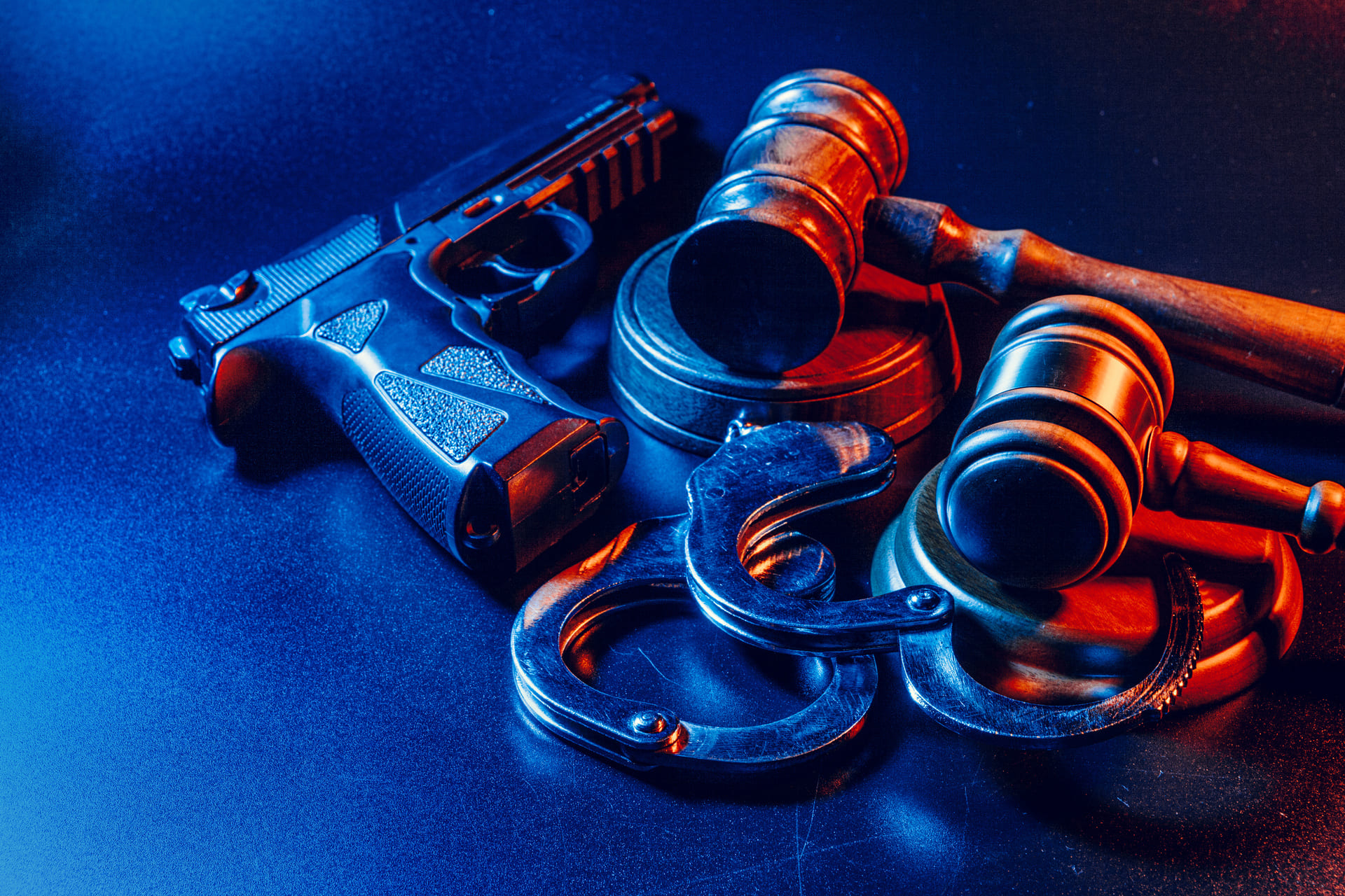 gun gavel and handcuffs under dramatic lighting