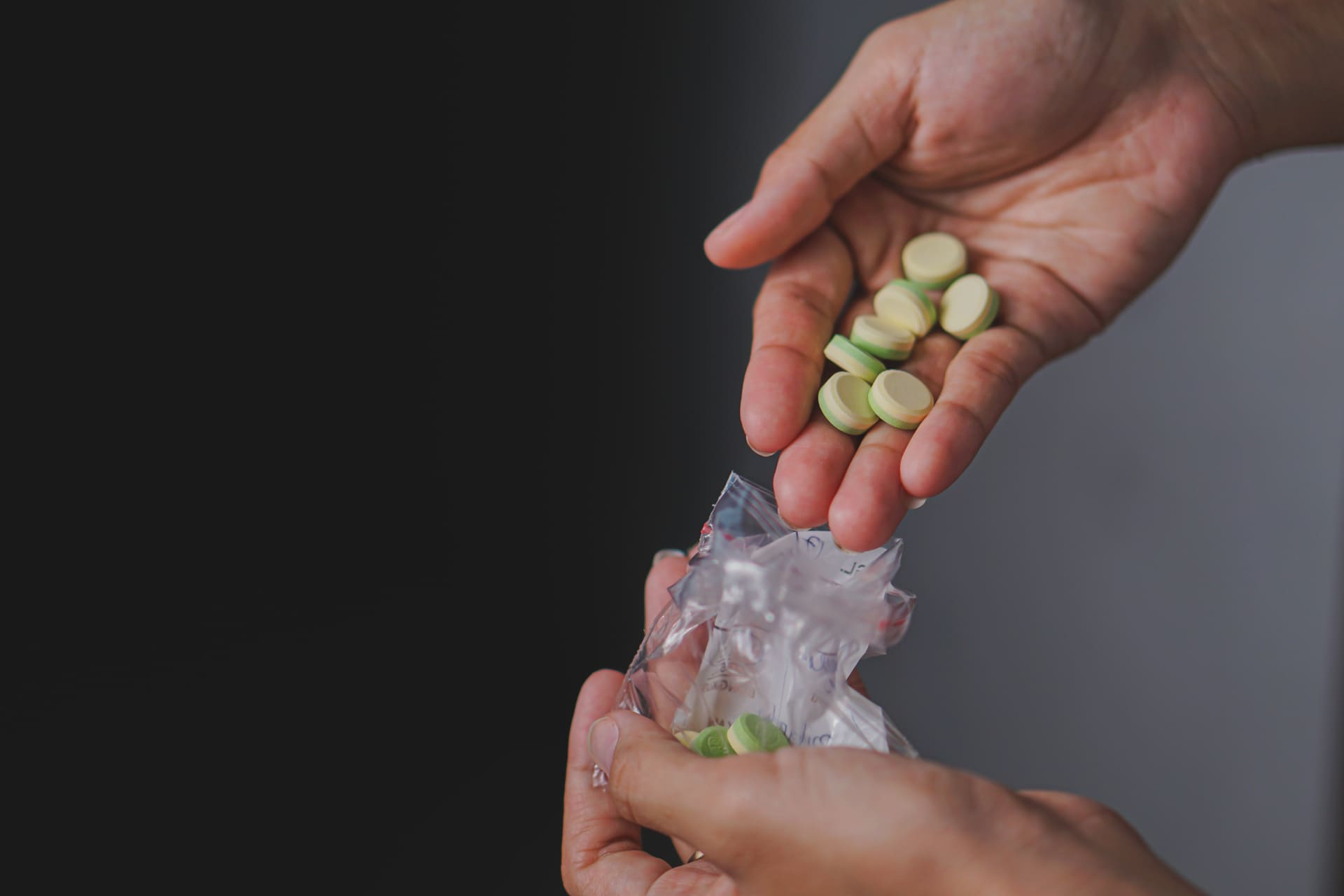 Hand holding suspicious pills